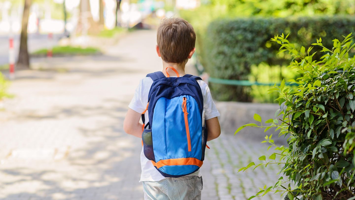 Ein Junge mit Schulranzen auf dem Rücken