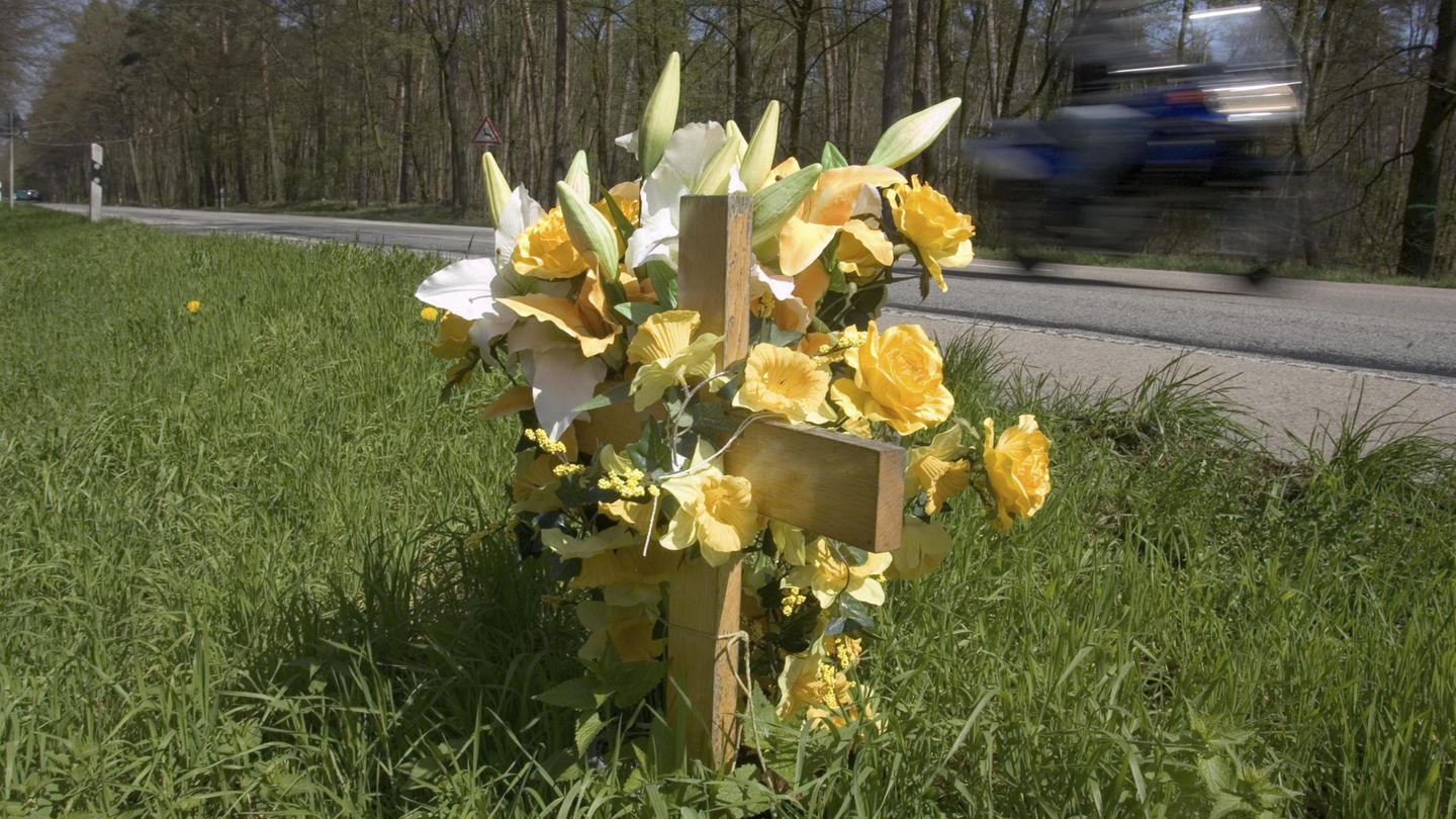 Ein mit Blumen geschmücktes Kreuz am Straßenrand
