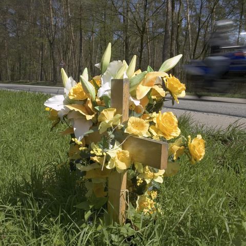 Ein mit Blumen geschmücktes Kreuz am Straßenrand