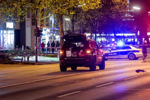 Mitten auf einer mehrspurigen Straße in Hamburg steht ein schwarzer Jeep mit offener Heckklappe. Im Hintergrund ein Polizeiauto