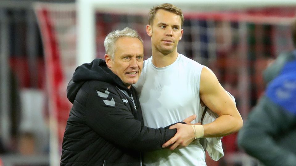 Christian Streich Manuel Neuer Trikot Arm in Arm stehen Freiburgs Trainer Christian Streich und Bayerns Torwart Manuel Neuer auf dem Platz. Streich hat Neuers Trikot