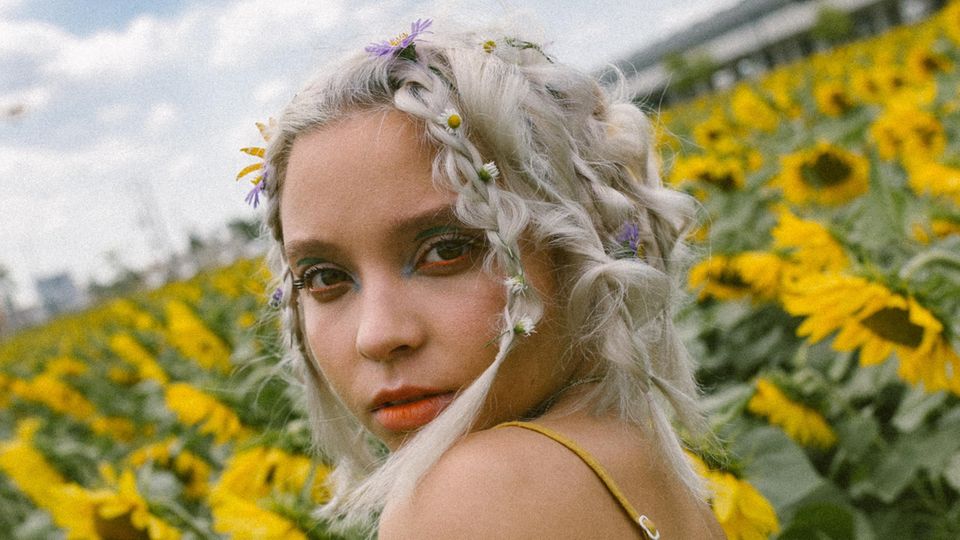 Ein blondes Mädchen in einem Feld aus Sonnenblumen