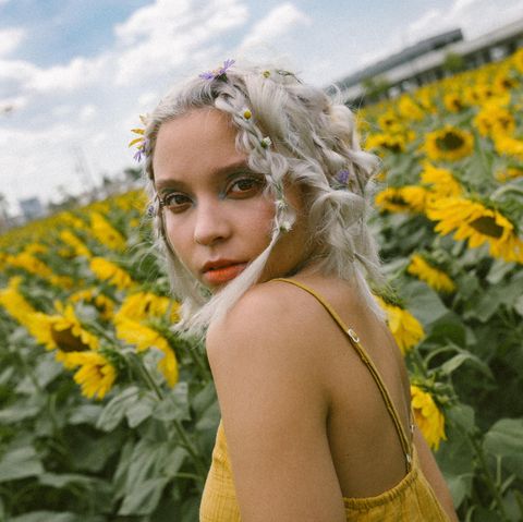Ein blondes Mädchen in einem Feld aus Sonnenblumen