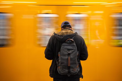 Ein Mann steht vor einer gelben U-Bahn in Berlin