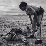 Die Polizistin Dorothy Onikute beugt sich über einen regungslosen Mann am Straßenrand