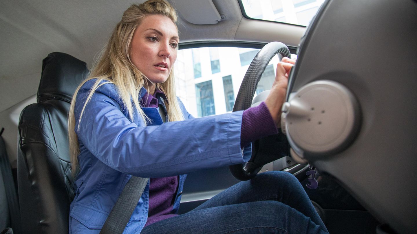 Frau schaltet Autoradio ein