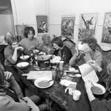 Kommunenmitglieder sitzen am Tisch und essen Suppe