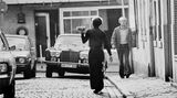 Ein Kellner trägt eine Mahlzeit über die Straße