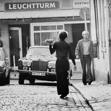 Ein Kellner trägt eine Mahlzeit über die Straße