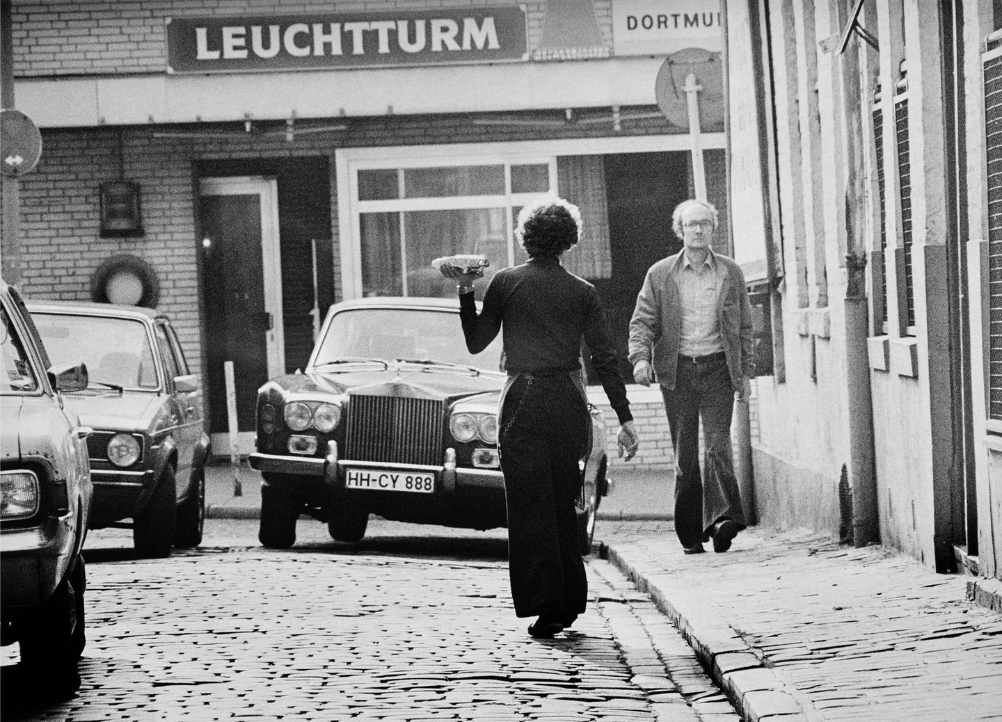 Ein Kellner trägt eine Mahlzeit über die Straße