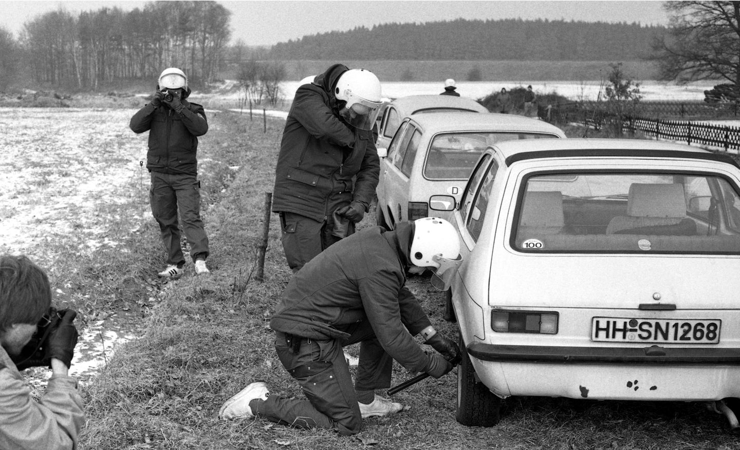 Ein Polizist lässt die Luft aus einem Autoreifen