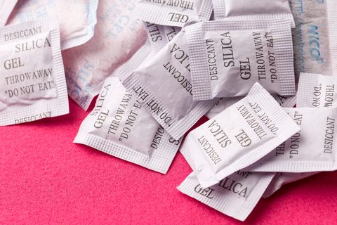 Mehrere kleine weiße Beutel mit Silica-Gel liegen auf einem Haufen