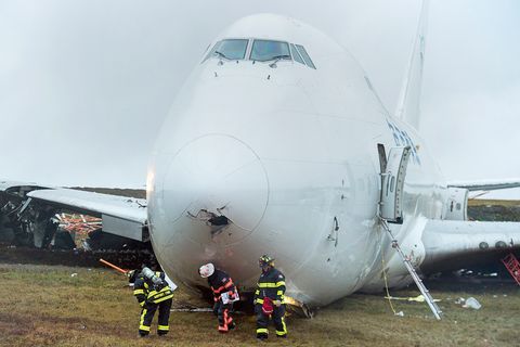 Rettungskräfte stehen vor einem Frachtflugzeug, das  von der Landebahn am Halifax Stanfield International Airport gerutscht ist.