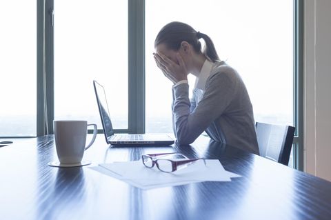 Eine Frau schlägt vor dem Laptop die Hände vor dem Gesicht zusammen