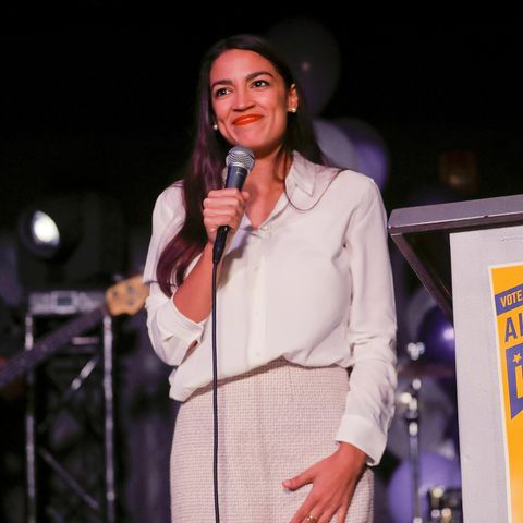 Alexandria Ocasio-Cortez steht auf der bühne und hält ein Mikrofon in der Hand