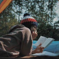 Person liest draußen ein Buch