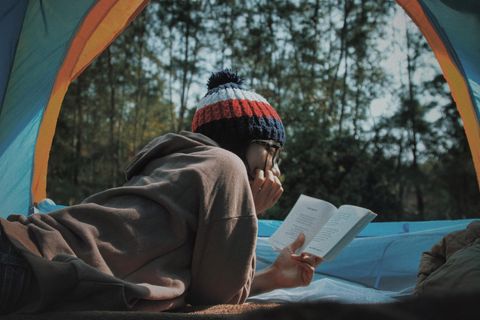 Person liest draußen ein Buch