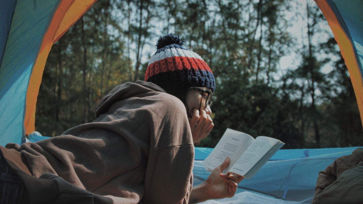 Person liest draußen ein Buch