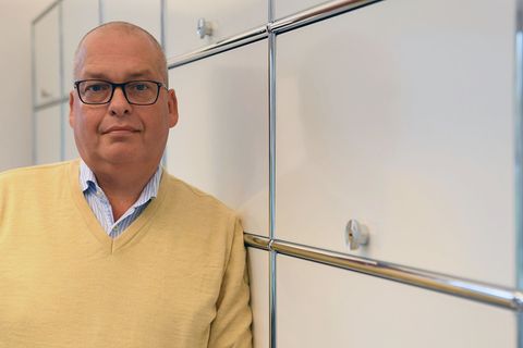 Ralf Zietz lehnt an einem Schrank in seinem Büro