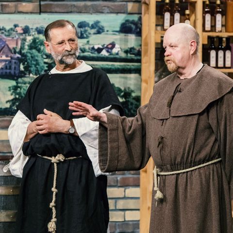 Wolfgang Streblow und Jürgen Hartwig treten im Mönchsgewand vor die Löwen.