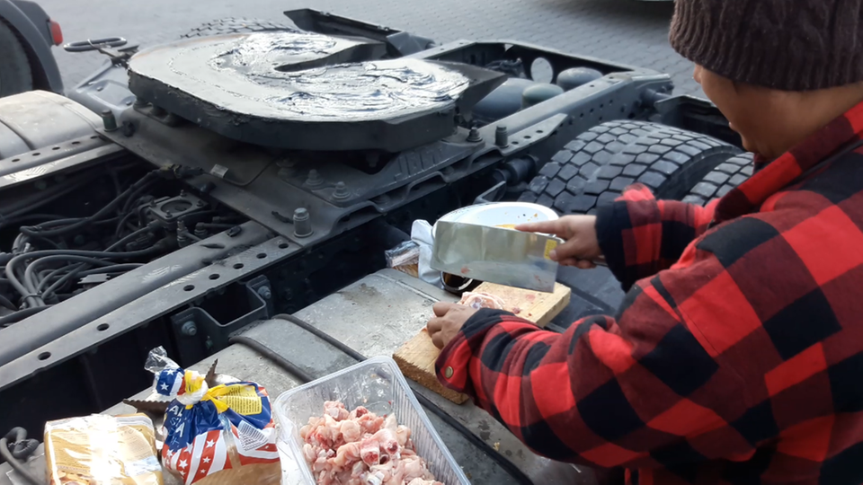 Ein philippinischer Fahrer schneidet Hähnchenfleisch Ein philippinischer Fahrer schneidet Hähnchenfleisch