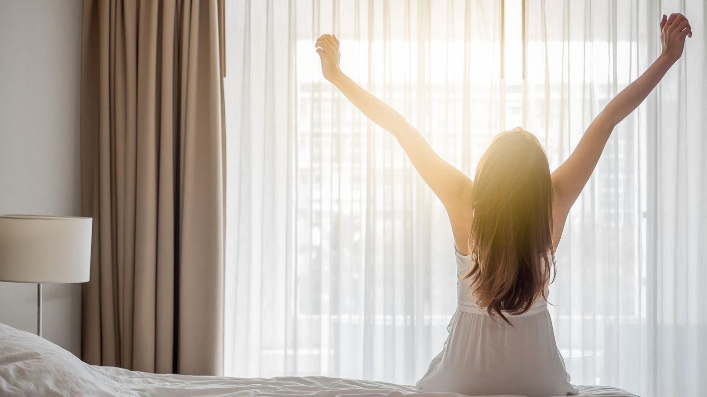 Frau sitzt auf dem Bett