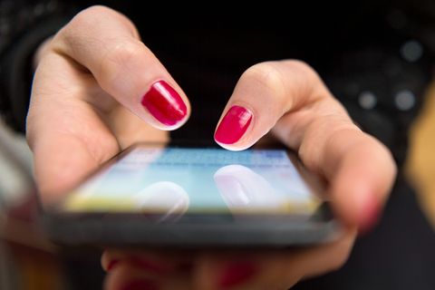 Frauenhände tippen auf ein Smartphone-Display