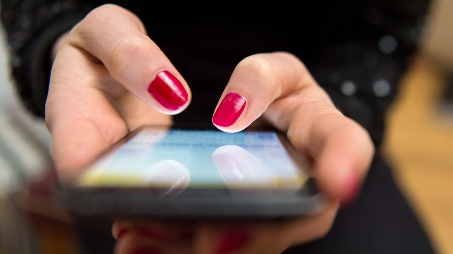 Frauenhände tippen auf ein Smartphone-Display