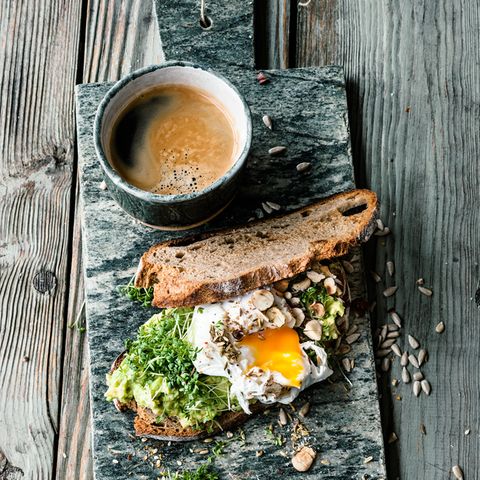 Avocado auf Röstbrot mit Nüssen, Sonnenblumenkernen, Ei, Kresse, Ducca und Kaffee