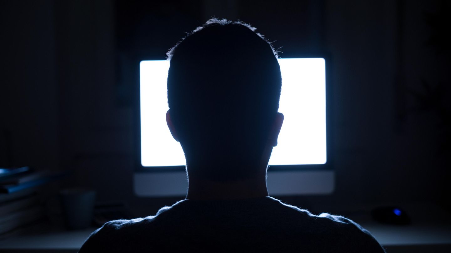 Anonymer Mann vor leuchtendem Bildschirm