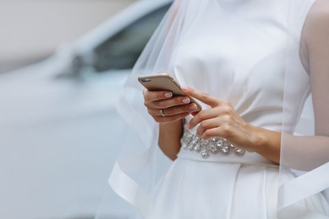 Eine Braut tippt auf dem Handy