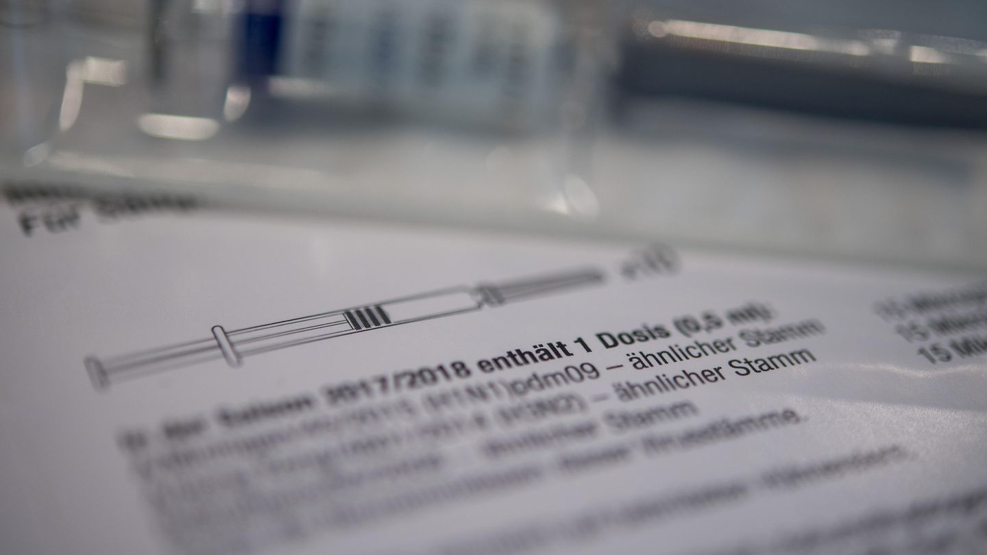 Eine Spritze mit Grippe-Impfstoff liegt auf einem Tisch