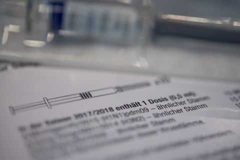Eine Spritze mit Grippe-Impfstoff liegt auf einem Tisch