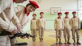 Jungarmisten bauen in der Turnhalle ihrer Schule ein Kalaschnikow-Modell auseinander.