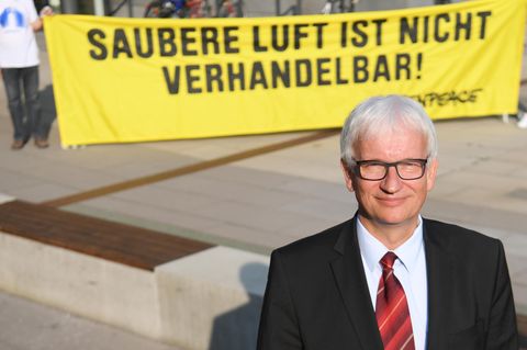 Jürgen Resch, einer der Geschäftsführer der Deutschen Umwelthilfe, im September vor Beginn einer Verhandlung über Diesel-Fahrverbote. Im Hintergrund ein Greenpeace-Plakat mit der Aufschrift "Saubere Luft ist nicht verhandelbar".