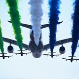 Der Airbus A380 von Etihad Airways von den Flugzeugen der Al Fursan Aerobatic im Formationsflug begleitet.