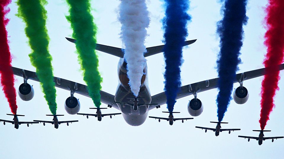Der Airbus A380 von Etihad Airways von den Flugzeugen der Al Fursan Aerobatic im Formationsflug begleitet.
