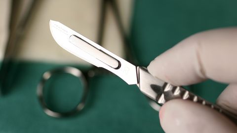 Ein Arzt hält ein Skalpell in der Hand