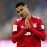 Serge Gnabry legt im Bayern-Trikot den Kopf schräg und die Hände vor der Brust zusammen