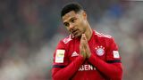 Serge Gnabry legt im Bayern-Trikot den Kopf schräg und die Hände vor der Brust zusammen