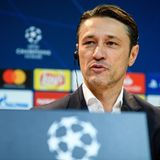 Niko Kovac sitzt auf einem Podium mit Champions-League-Loho und hört mit Knopf im Ohr einer Frage zu