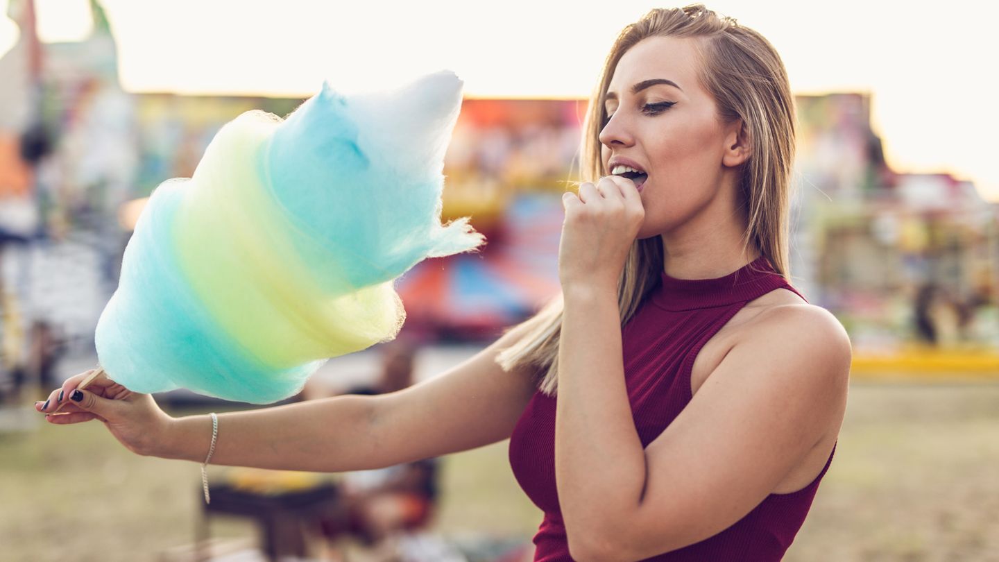 Frau isst Zuckerwatte