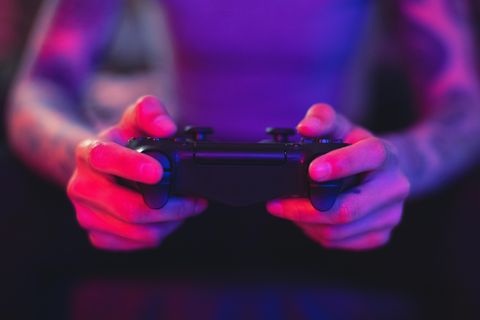 Ein Gamer hält eine Playstation-Konsole in den Händen