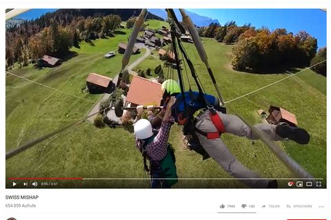 Mit aller Kraft klammert sich Chris Gursky an den Hängegleiter und den Piloten