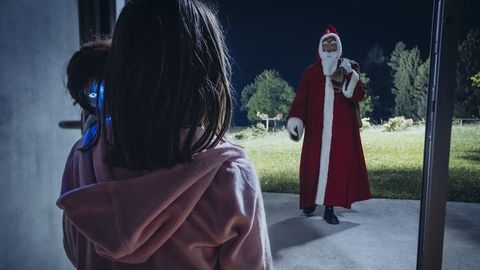Eine sprechende Puppe führt Kinder in der Nacht ins Wohnzimmer, wo sie den Weihnachtsmann erwarten