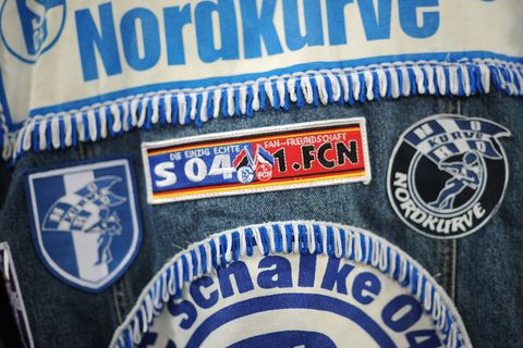 Ein Fan des FC Schalke 04 trägt eine Jeansjacke mit Aufnähern, darunter "Nordkurve"