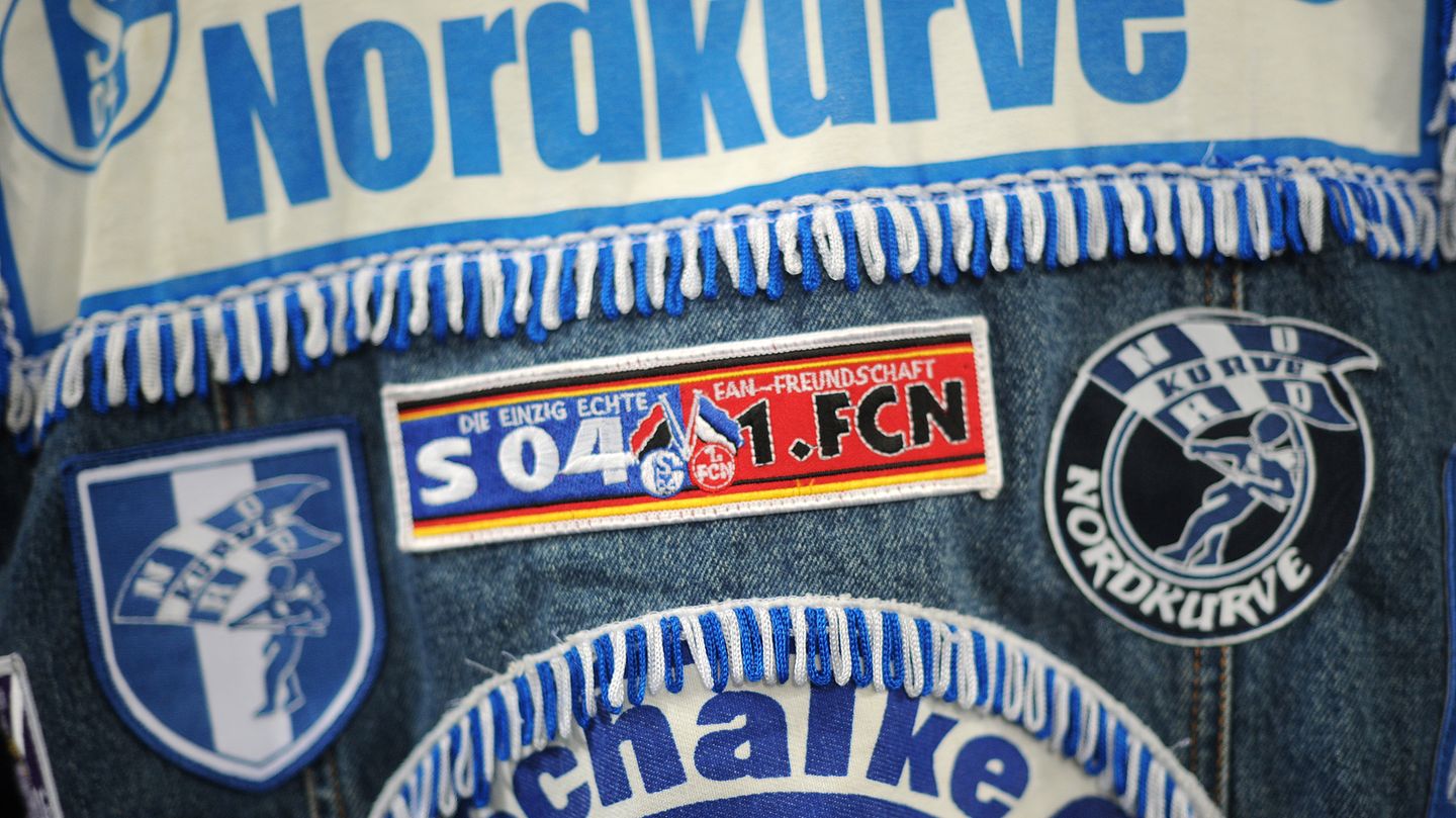 Ein Fan des FC Schalke 04 trägt eine Jeansjacke mit Aufnähern, darunter "Nordkurve"