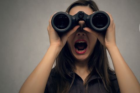 Junge Frau sucht mit einem Fernglas