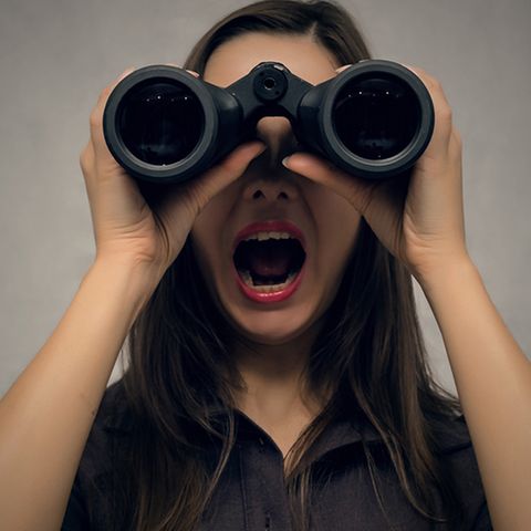 Junge Frau sucht mit einem Fernglas
