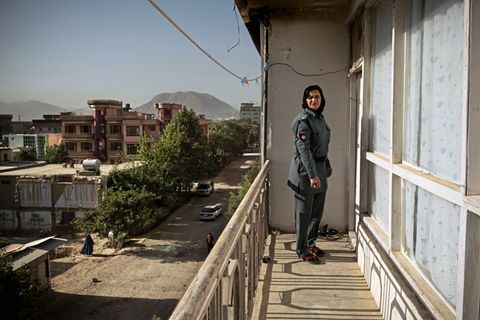 Schamila steht in Uniform auf dem Balkon ihrer Wohnung. Im Hintergrund kann man die Berge des Hindukuschs erkennen. Schamila wurde als Zwölfjährige entführt und von Afghanistan nach Pakistan verschleppt.